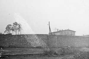 Fragment muru okalającego podobóz. W głębi górna część piętrowego budynku w koszarach SS. Od 1945 roku w części budynku mieszkał komendant COP. Stan z dn. 11.3.1959 r. Fot. T. Szymański. Ze zbiorów Archiwum Państwowego Muzeum Auschwitz - Birkenau.