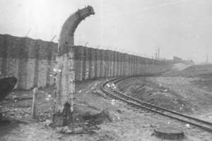 Narożny słup ogrodzenia obozu oraz fragment muru ogradzającego teren. Stan z dn. 11.3.1959 r. Fot. T. Szymański. Ze zbiorów Archiwum Państwowego Muzeum Auschwitz - Birkenau.